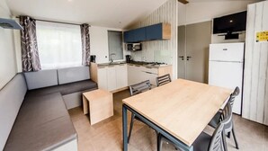 A compact kitchen with a dining area, including a bench and a table.