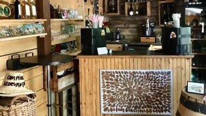 A rustic interior with wooden shelves displaying various bottles and a counter with a patterned mat.