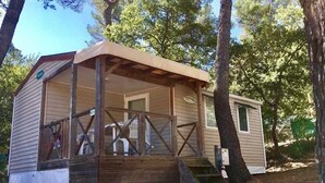 A small cabin with a porch, wooden steps, and a covered area.