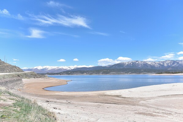 A lake with mountains in the background and a clear sky.
