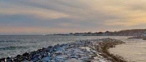 A rocky shoreline with waves crashing against it.