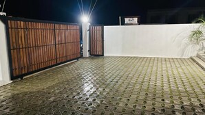 A gated entrance with a tiled floor, a white wall, and a sign above the gate.