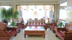 Una habitación tradicional con muebles de madera, incluyendo sofás y una mesita de centro, y plantas en macetas.