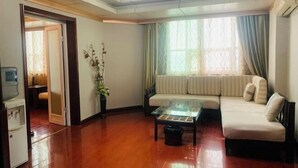 Una sala de estar con un sofá, una mesa de centro de cristal y un radiador.