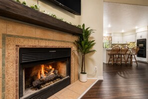 Une cuisine moderne avec une cheminée, une table à manger en bois et des chaises.