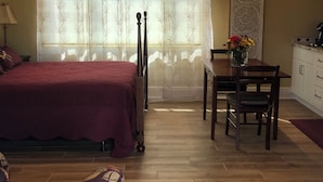A bedroom with a bed, a desk, and a chair.