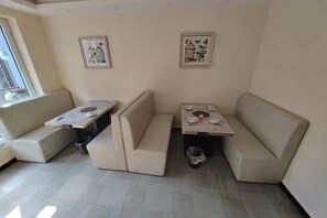 Quarto nos fundos com sofá, mesa pequena e lixeira.