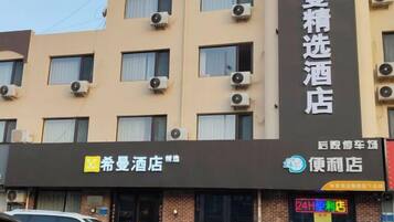 A hotel building with multiple windows and air conditioning units.