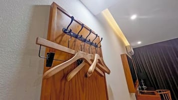 A wooden door with a coat rack and a wall-mounted towel rack.