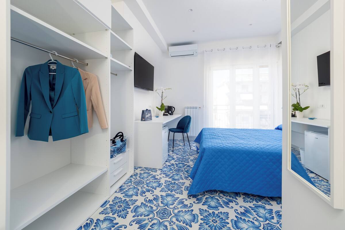 Une chambre à coucher avec un lit, un bureau, une chaise et une armoire.