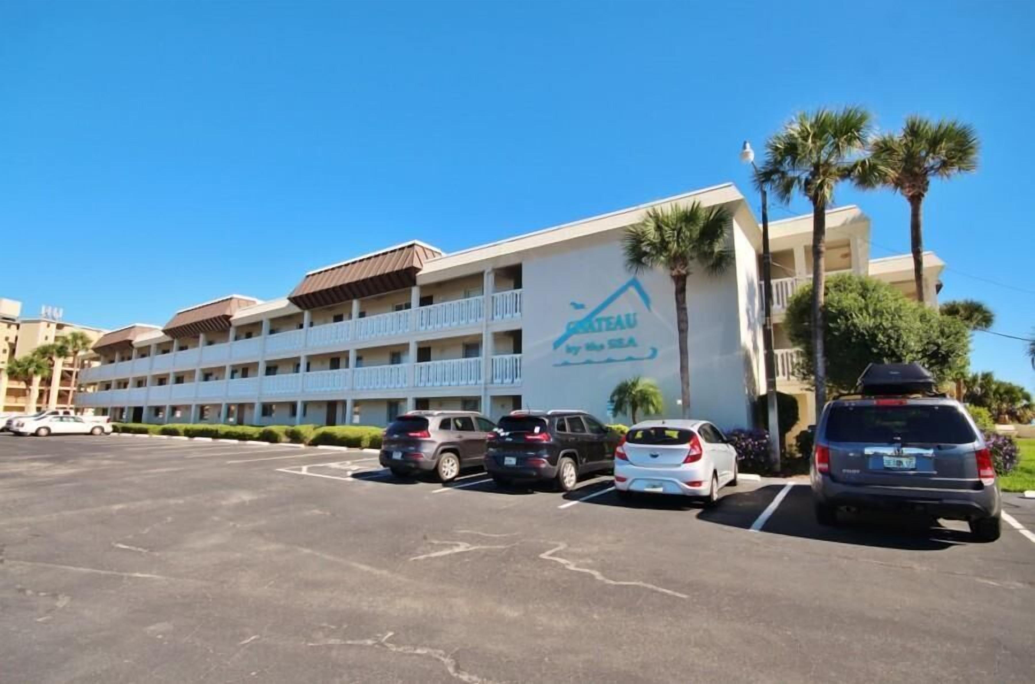 Un hotel con un letrero que dice "GRIEAU by the sea" y un estacionamiento con varios coches.