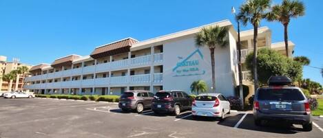 Un hotel con un letrero que dice "GRIEAU by the sea" y un estacionamiento con varios coches.