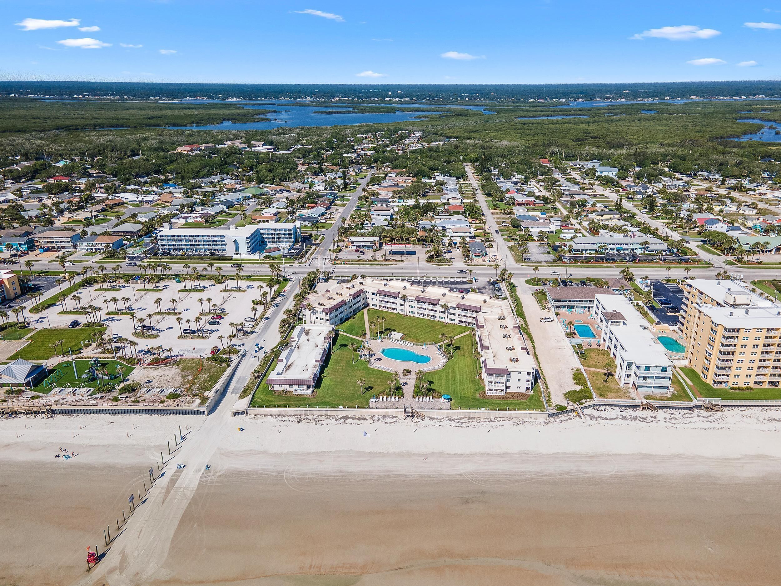 A coastal resort with a central pool, beachfront, and a marina.