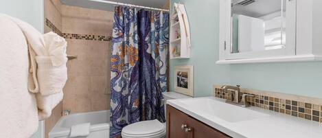 Un baño con bañera, inodoro y lavamanos.