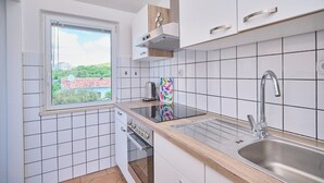 A compact kitchen with white cabinets, a window, and a stainless steel sink. - Apartment Meri #2 by Litto (Basinci)