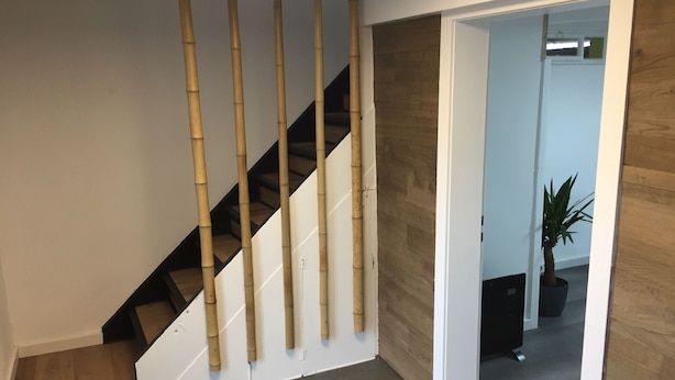 Un escalier au design moderne, avec une main courante noire et des marches blanches.