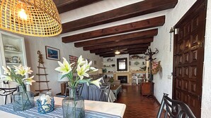 A dining area with a table set for two, featuring a striped tablecloth and glass vases with flowers. - El Rincón del Montgó - private swimming pool (Xàbia)
