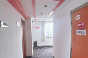 A hotel corridor with a red door, a sign indicating a room type, and a window with curtains. - Dingding Hotel (Shanghai Pudong Airport Heqing Town) (Shanghai)