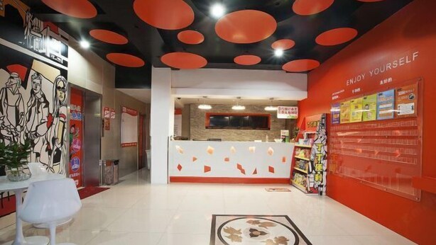 A reception area with a modern design, featuring a counter, seating area, and informational posters on the walls. - Dingding Hotel (Shanghai Pudong Airport Heqing Town) (Shanghai)