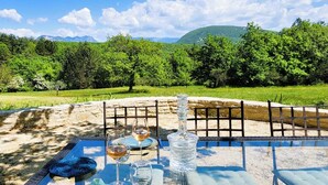 An outdoor dining area with a table set for two, a wine glass, and a bottle. - Domaine de la Pigne, tranquillity as far as the eye can see (Puy-Saint-Martin)