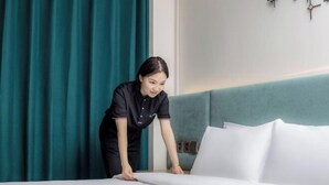 A hotel room with a neatly made bed, teal curtains, and a white headboard. - Beijing Ruistin Hotel (Beijing Daxing New Airport Qingyuan Road Subway Station) (Beijing)