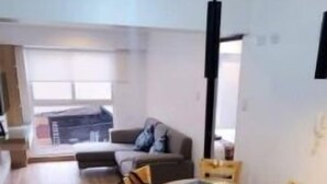 Una cocina moderna con una isla central, armarios de madera y un comedor con mesa redonda y sillas.