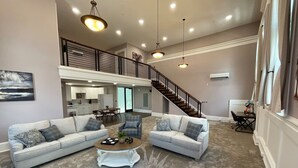 Un salon spacieux comprenant deux canapés, une table basse et un escalier menant à un niveau supérieur.