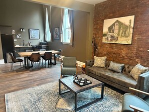 A modern living room with a dining area, a sofa set, and a coffee table. - One Zero Five Stay 304 (Barre)