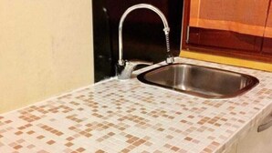 A kitchen with a tiled backsplash, a stainless steel sink, and a faucet. - CA' DI LUNA VENEZIA  (Venice)