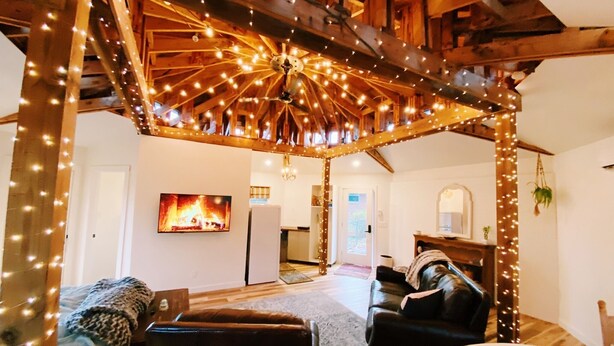 Un salon chaleureux avec un plafond en bois, une cheminée et un téléviseur.