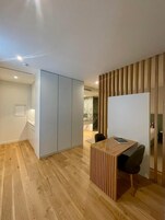 Una habitación moderna con un escritorio de madera, una silla y un armario.