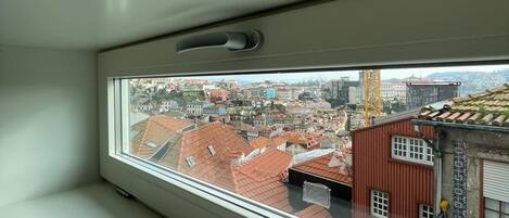 A room with a window overlooking a cityscape.