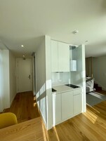 Una cocina moderna con armarios blancos, estufa integrada y encimera.