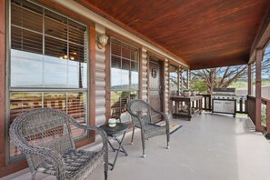 A covered patio with wicker furniture, a grill, and large windows. - Casa del Lago PK- near lake and perfect for entertaining! (Strawn)