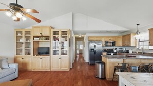 A spacious kitchen with wooden cabinets, a central island, and a ceiling fan.