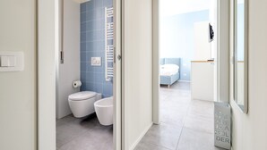 A modern bathroom with a toilet, bidet, and towel rack. - Charming studio near the city centre (Milan)
