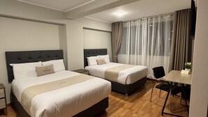 A hotel room with two beds, a small table, a chair, and a TV. - HOTEL INKALMA SANTA MARTA (Arequipa)