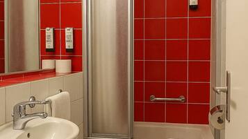 Un baño con lavamanos, inodoro y ducha.