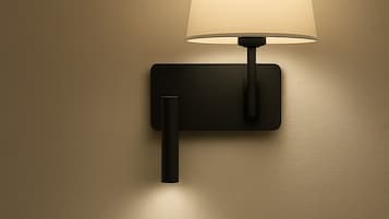 A wall-mounted lamp with a rectangular base and a cylindrical shade.