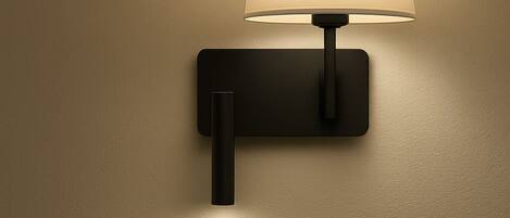 A wall-mounted lamp with a rectangular base and a cylindrical shade.
