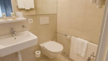 A modern bathroom with a sink, toilet, and shower area.