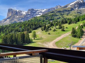 A mountainous landscape with a ski lift, a dirt path, and a building with a red roof. - COSY stay at the MONTAGNE-STUDIO for 4/5 people - at the foot of the slopes (Unknown)