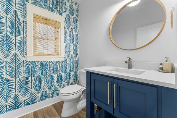 Une salle de bain avec des toilettes, un lavabo et un miroir.