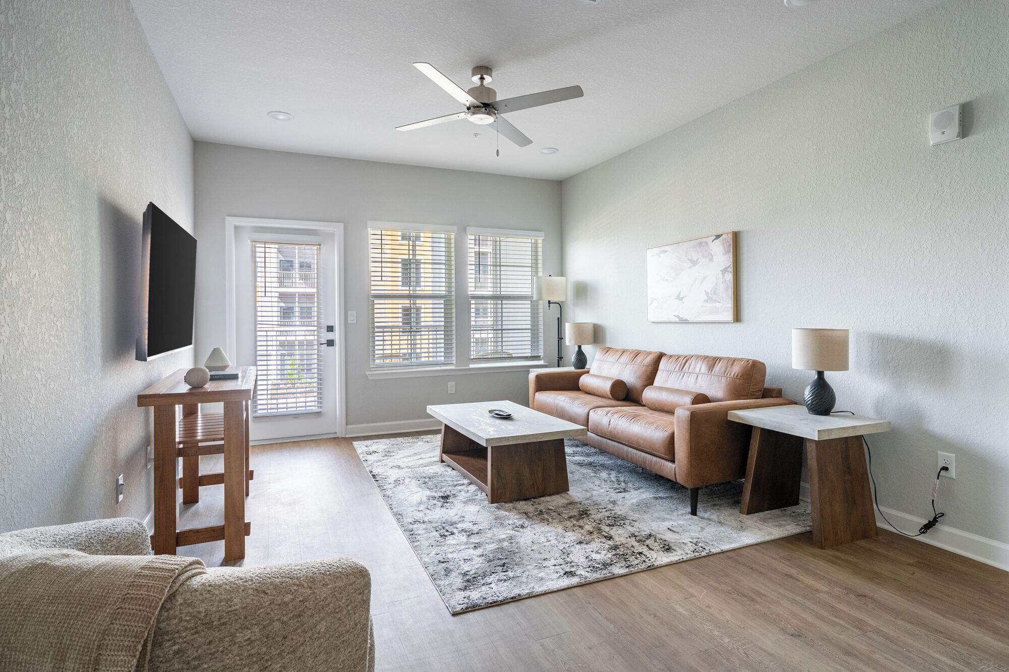 A modern living room with a sofa, coffee table, and a ceiling fan.