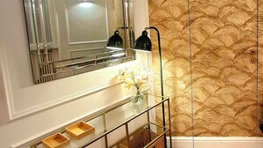 A bathroom with a large mirror, wooden floor, and a textured wall. - TALISMANO LUXURY MAISON (Napoli)