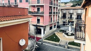 A multi-story building with balconies, a courtyard with a fountain, and a street view. - Nautilus B & B  (Scalea)