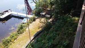Un quai avec un bateau, un drapeau américain et une table entourée de chaises.