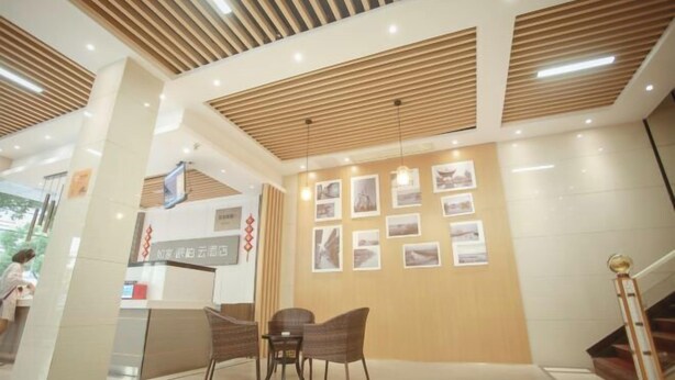 A reception area with a wooden ceiling, a reception desk, and framed pictures on the wall.