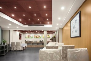 A restaurant with a modern interior, featuring a wooden ceiling, seating area, and a wall-mounted menu board. - Rujia Pebble Hotel (Baoying Anyi East Road, Baoying Yangzhou) (Baoying)