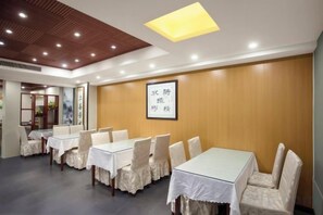 A conference room with tables and chairs, wooden panel walls, and a ceiling with recessed lighting. - Rujia Pebble Hotel (Baoying Anyi East Road, Baoying Yangzhou) (Baoying)